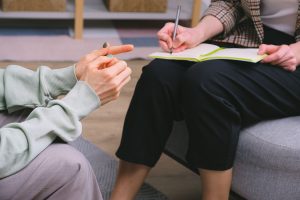Close-up of drug and alcohol counsellor taking notes